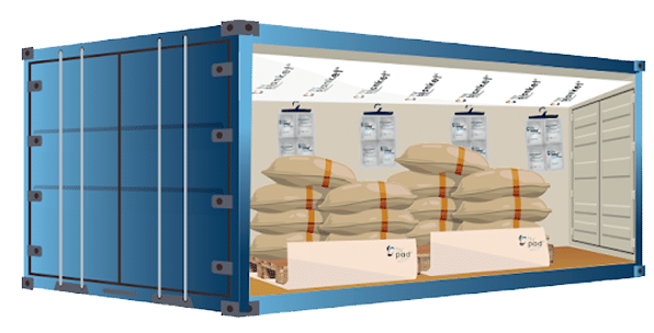 A blue shipping container with its side open, showing large sacks stacked on pallets and several white desiccant bags hanging from the ceiling, likely to protect the cargo from moisture.